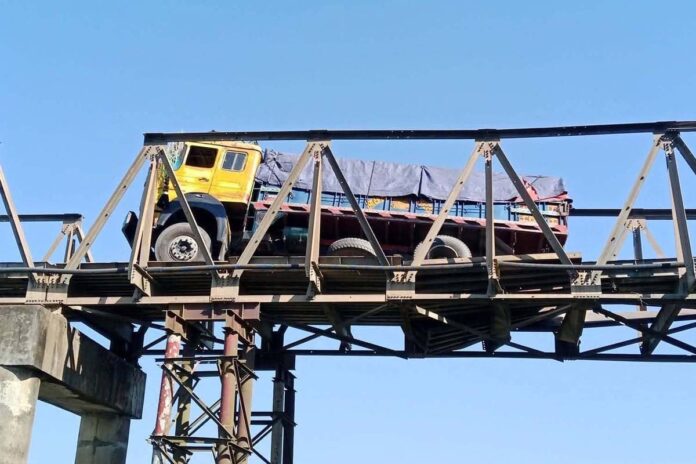 1764927925-c6457bdeb29a304a45b5f86c0c2e93c5 পাটাতন ভেঙে বেইলি ব্রিজে আটকা পড়লো ট্রাক